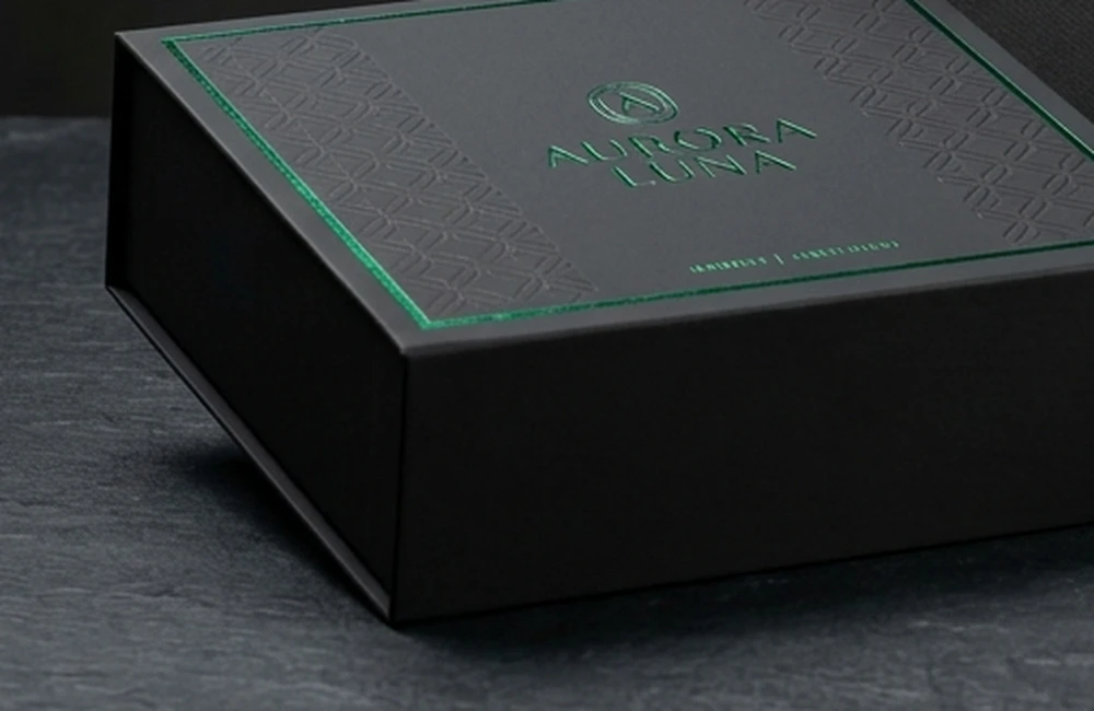 Luxury custom packaging box with metallic emerald foil stamping and tactile embossing for a prestige brand